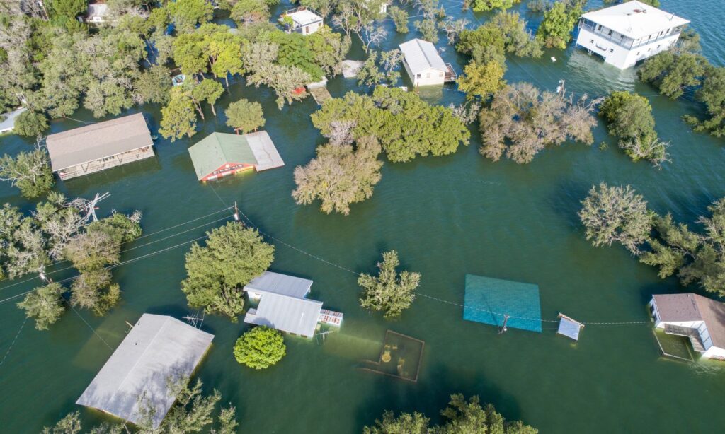 Aerial view of a flooded neighborhood, with houses partially submerged in water.