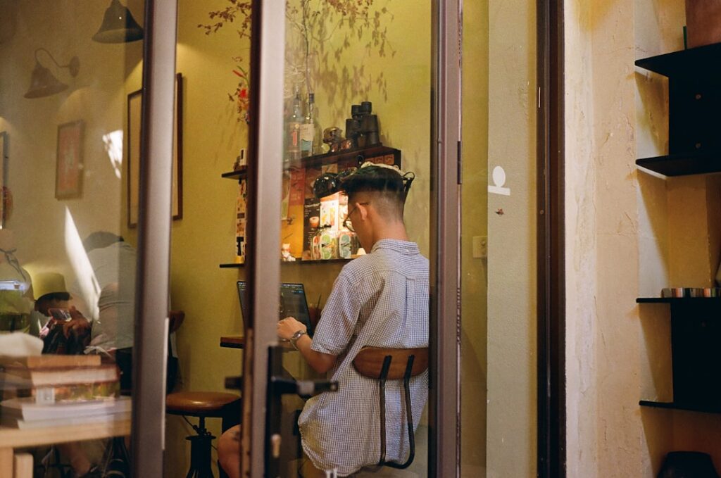 Professional home inspector with a clipboard carefully examines an open electrical breaker box inside a residential home.