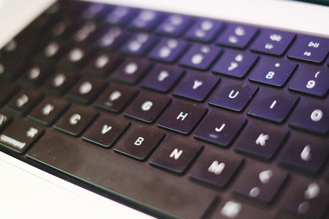 A set of modern house keys rests on a sleek laptop keyboard, symbolizing the intersection of real estate and technology in today's market.